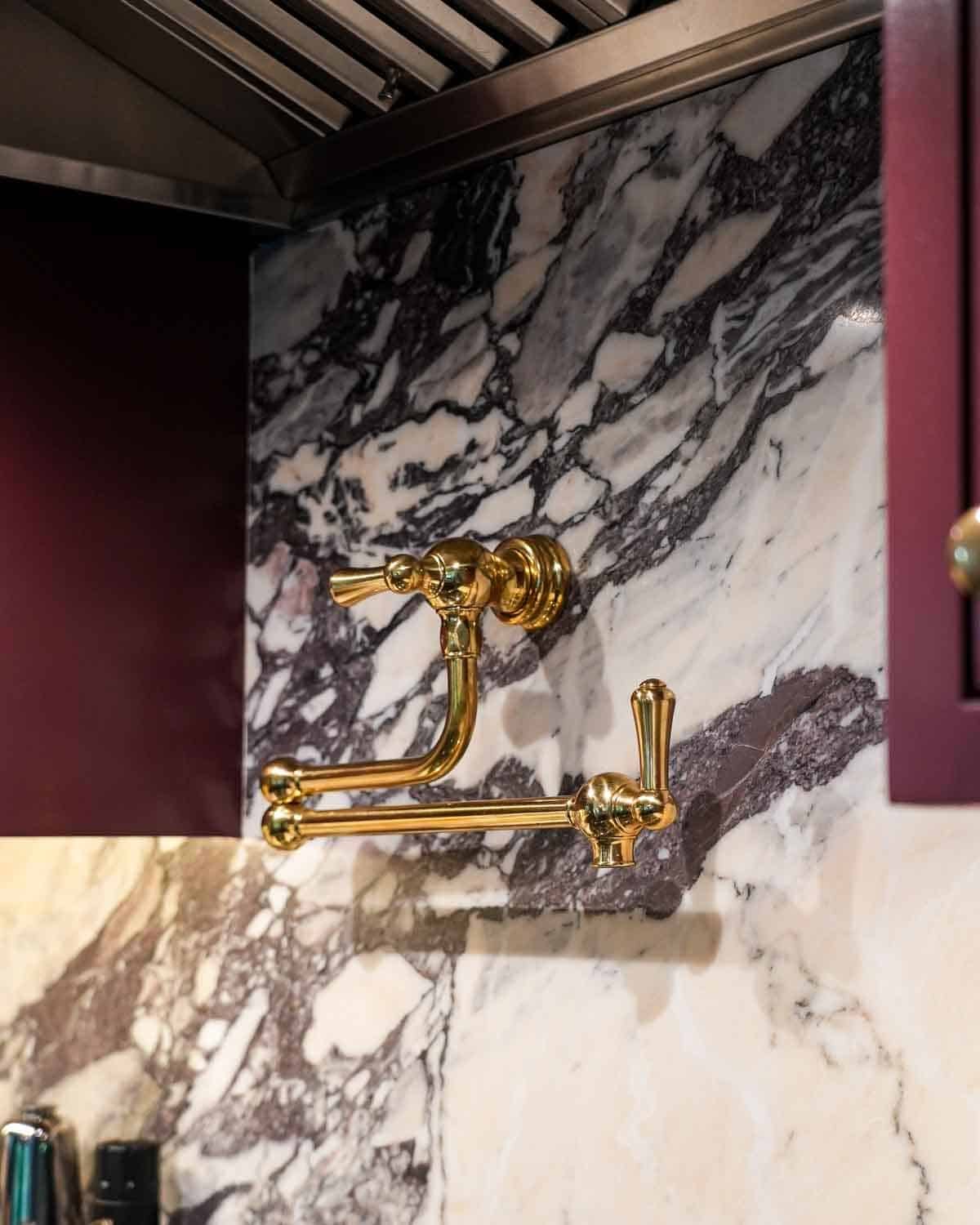 Marble kitchen with a brass pot filler.