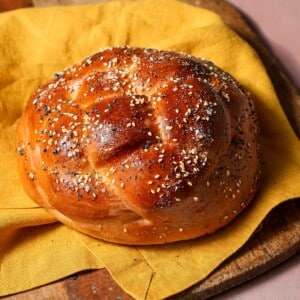 a 4 strand round challah with sesame and poppy seeds.