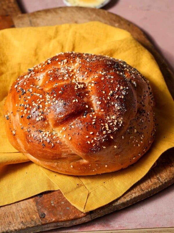 a 4 strand round challah with sesame and poppy seeds.