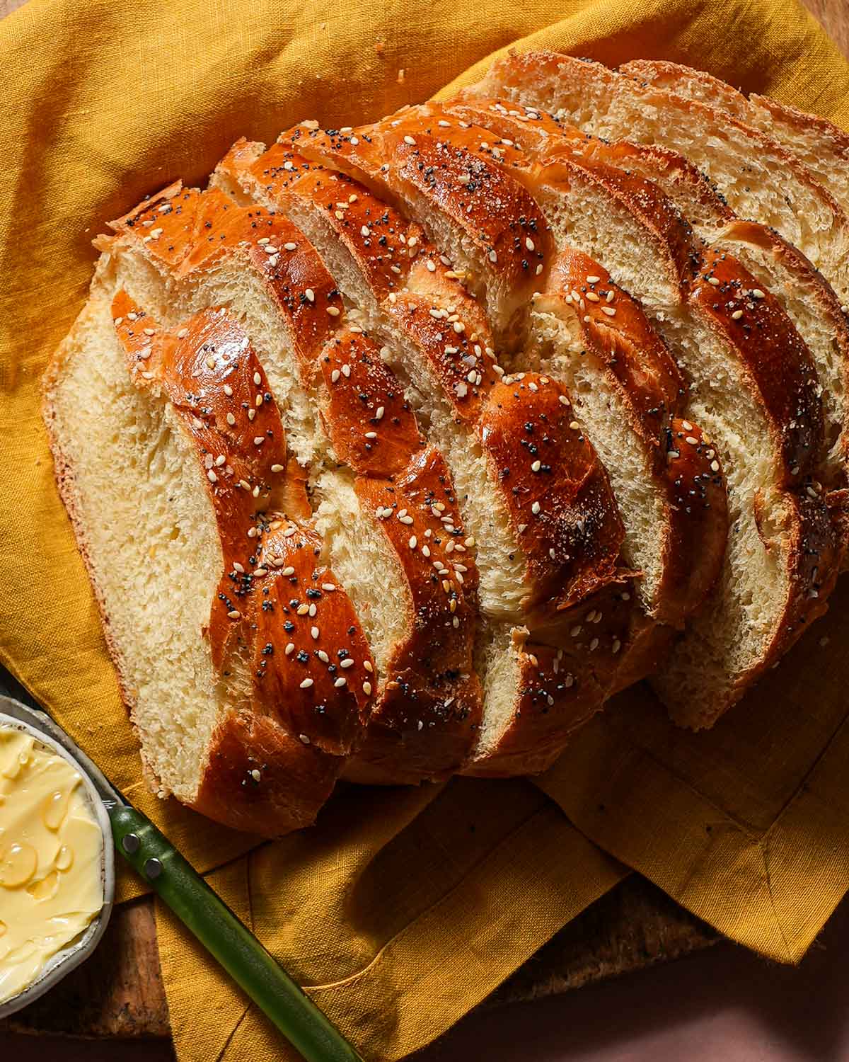 Sliced challah bread with butter and honey.