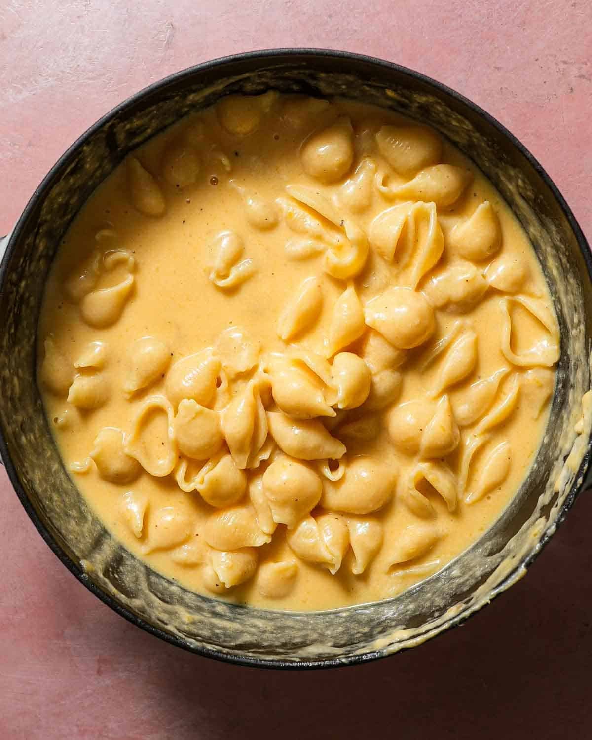 A pot of butternut squash mac and cheese with shell pasta.