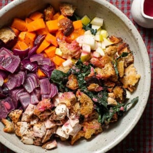 A large bowl of the ingredients to make a Fall panzanella salad with cranberry dressing.