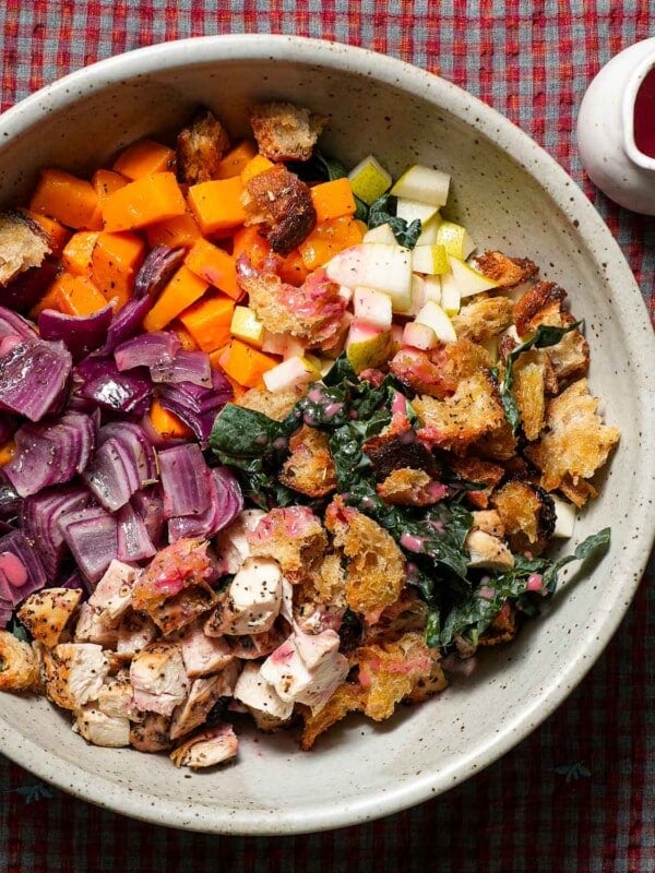 A large bowl of the ingredients to make a Fall panzanella salad with cranberry dressing.