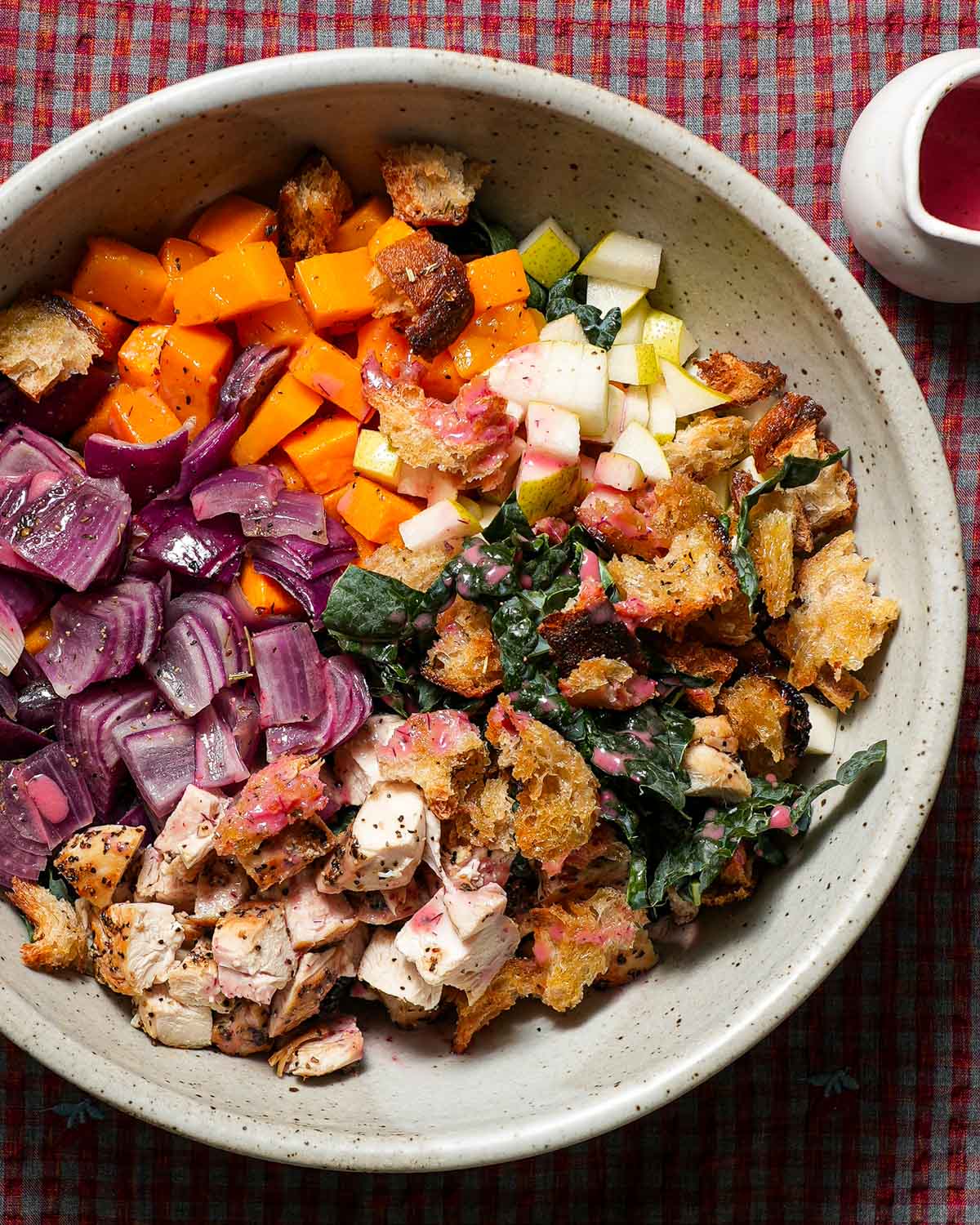A large bowl of the ingredients to make a Fall panzanella salad with cranberry dressing.