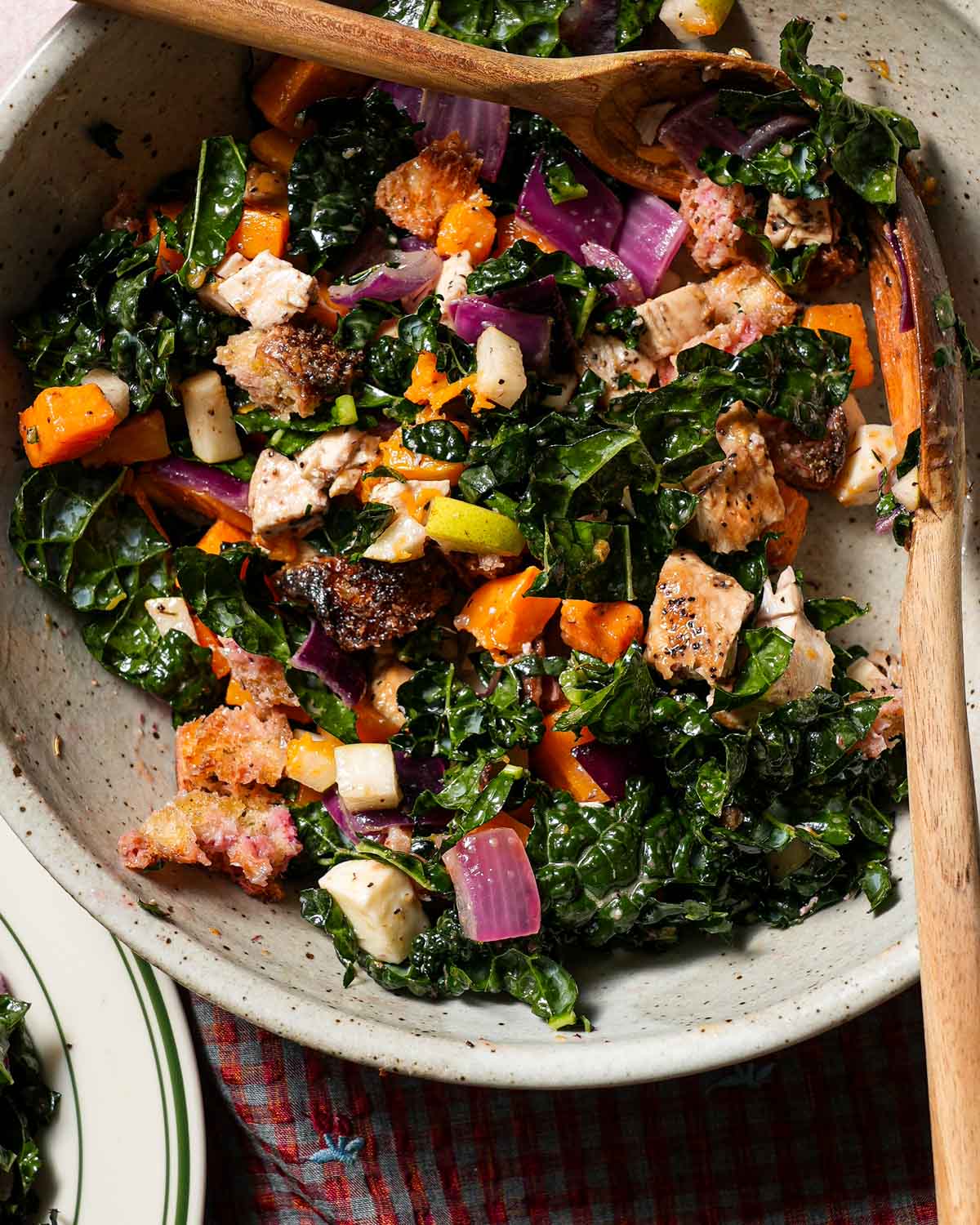 A bowl of tossed Fall panzanella salad with tongs.
