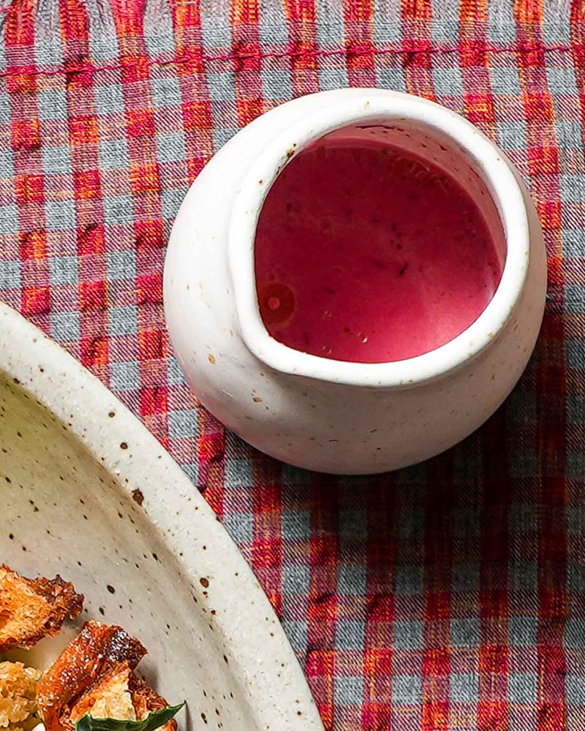 A carafe of cranberry vinaigrette ready to be poured over salad.