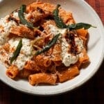A bowl of chili crisp pumpkin rigatoni with sage.