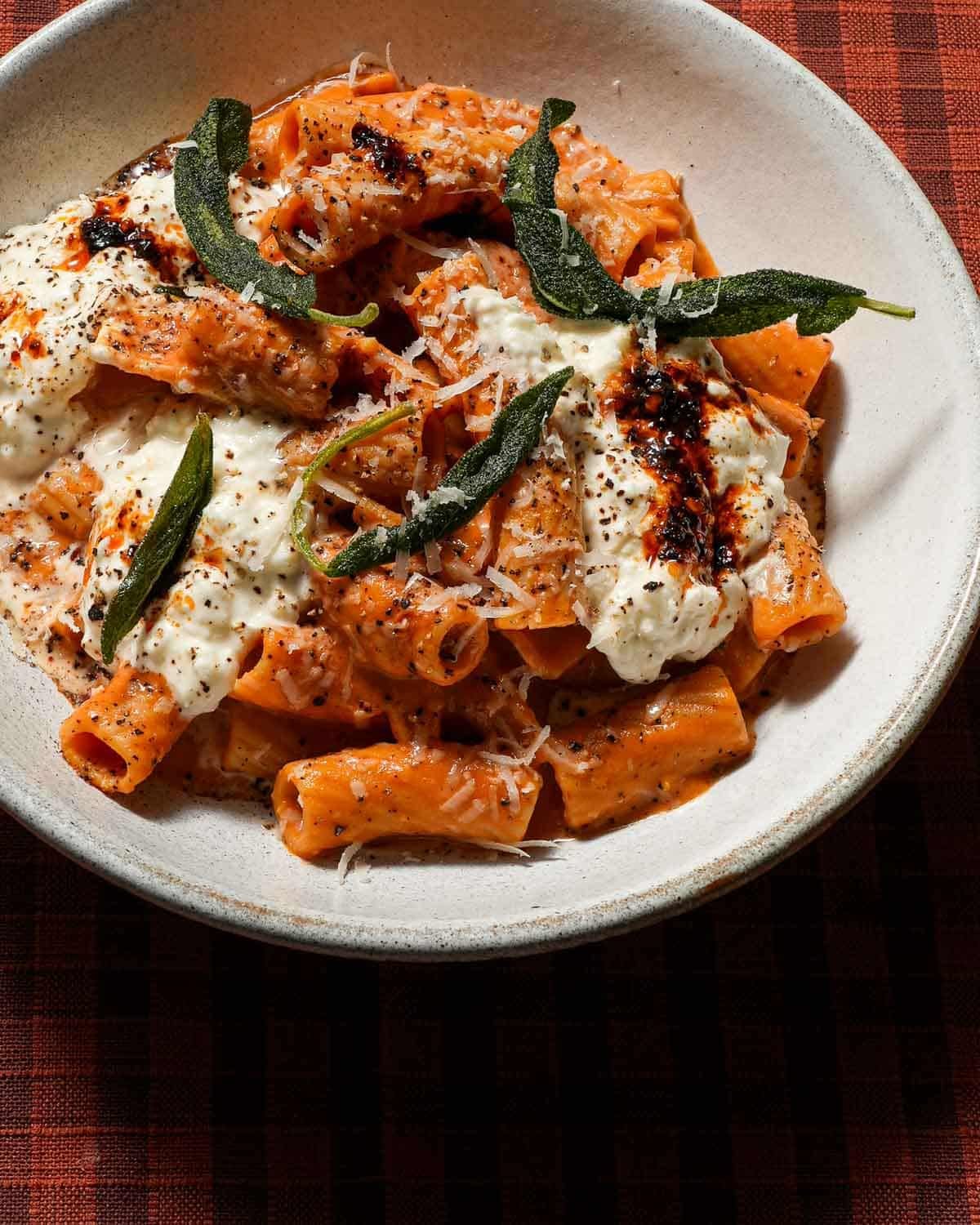 A bowl of chili crisp pumpkin rigatoni with sage.