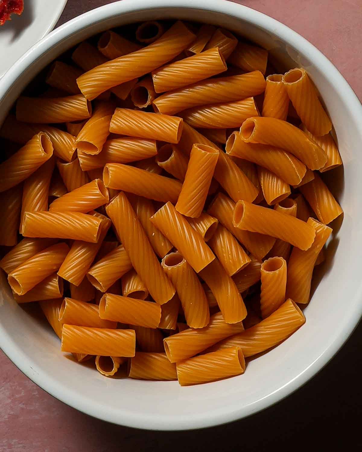 A bowl of gluten-free, protein packed Banza pasta in a white bowl.